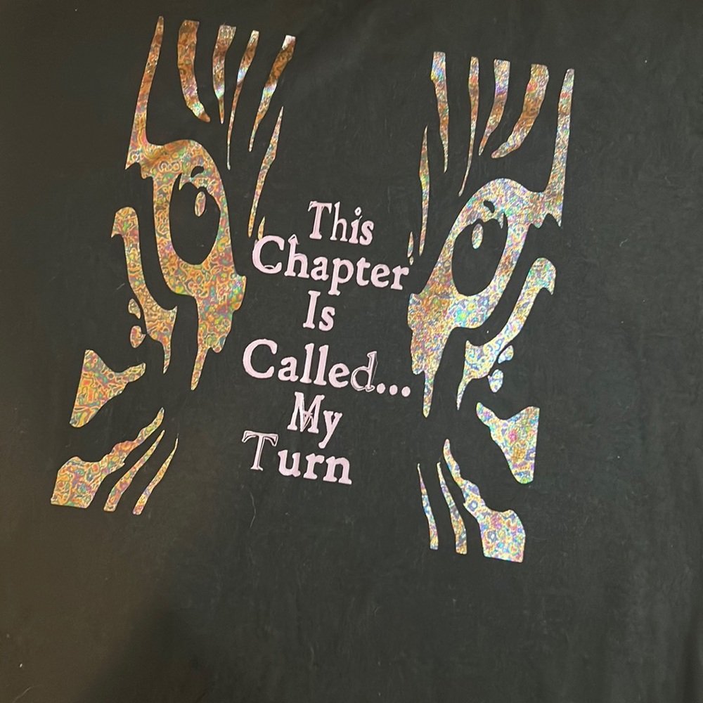 Black w iridescent eyes and purple writing